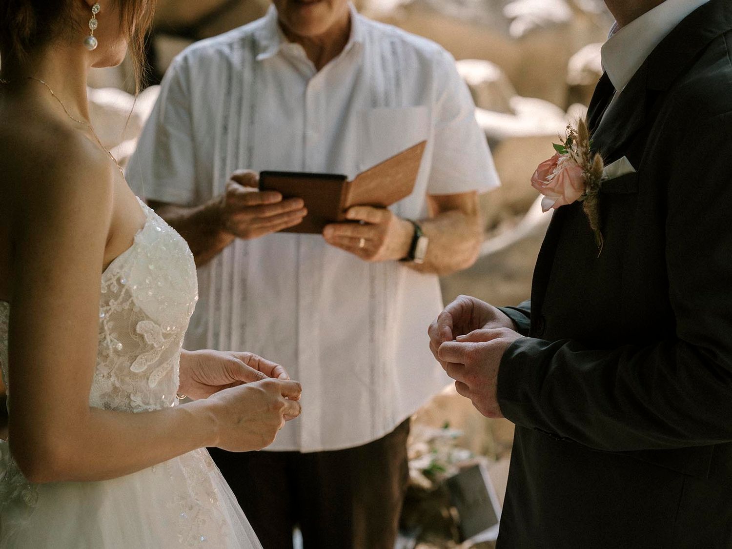 A couple exchanges vows during an intimate outdoor wedding ceremony.