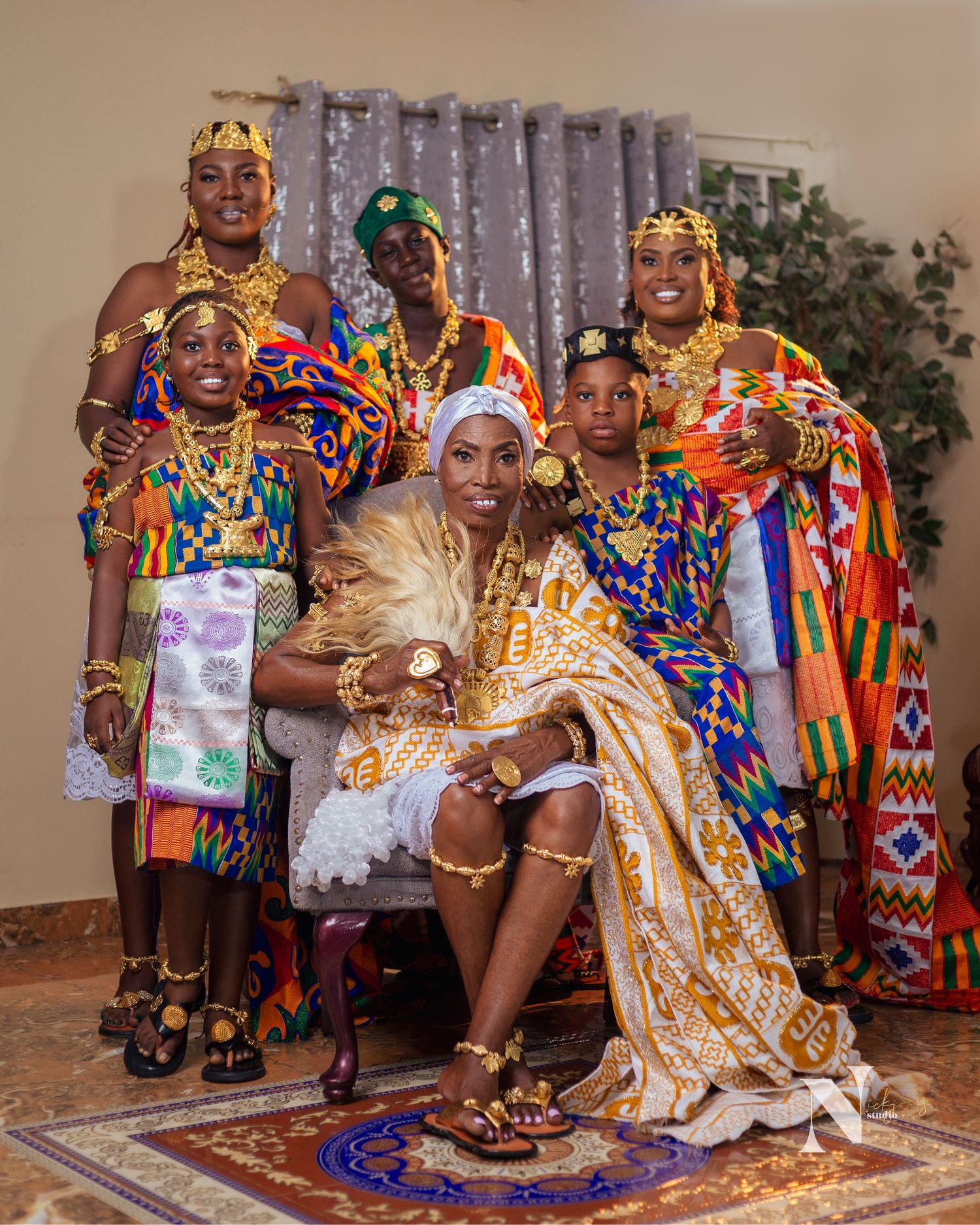 Group photo featuring people in vibrant traditional African attire and ceremonial dress.