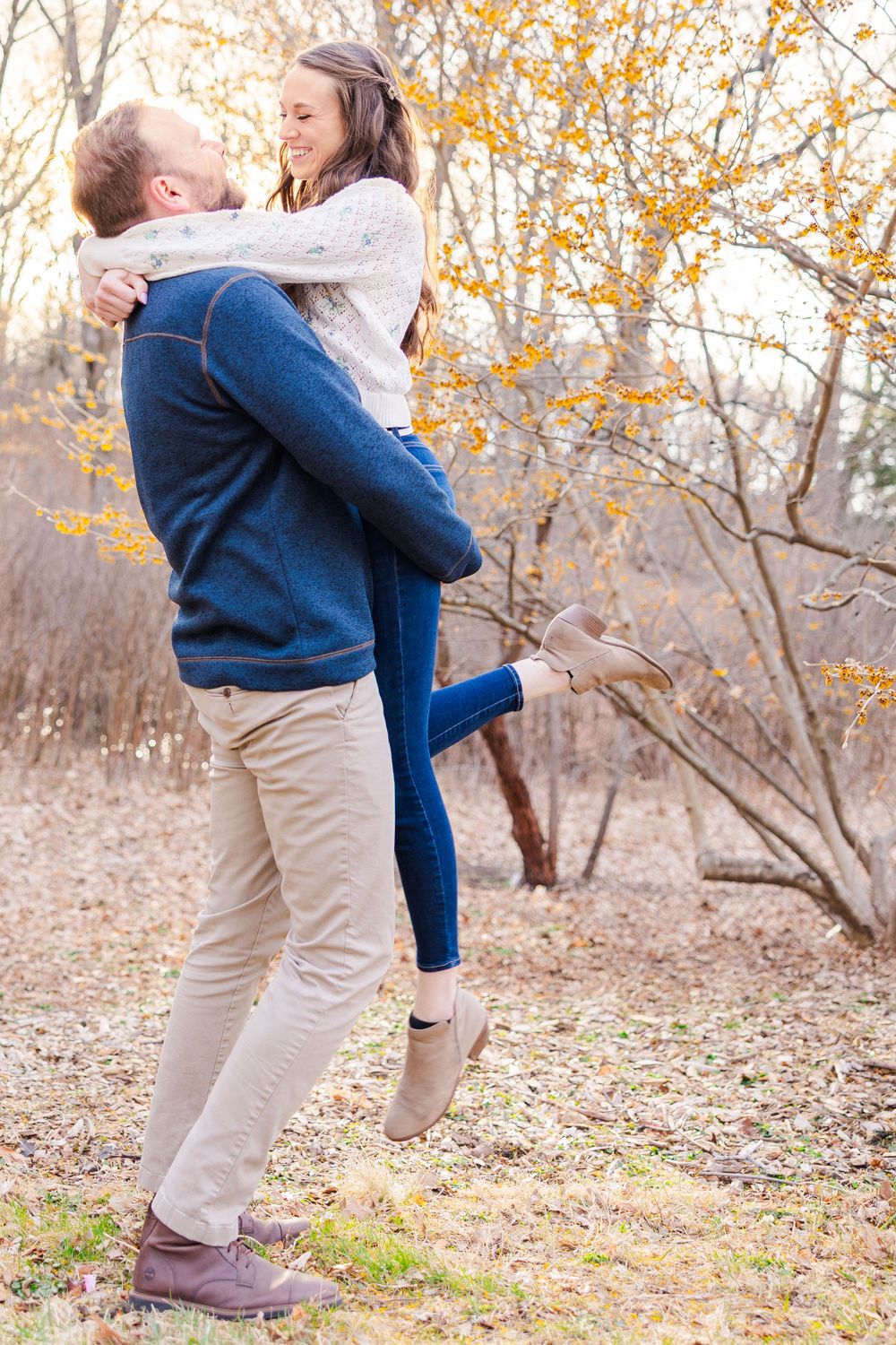 A playful couple embraces during their fall engagement photoshoot.