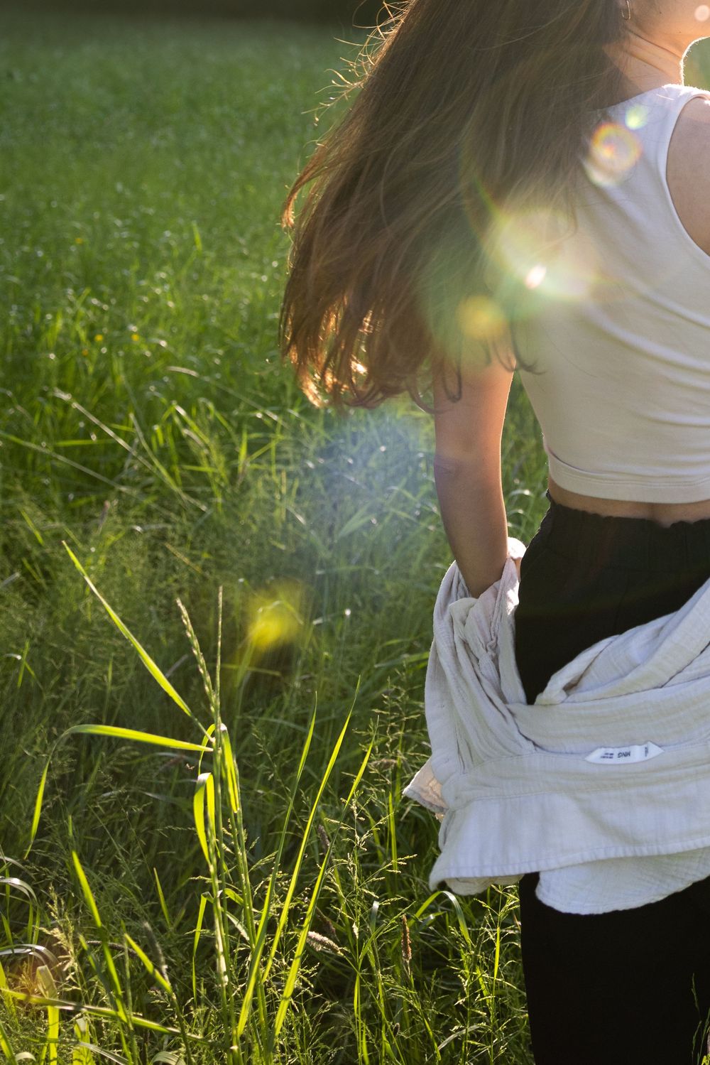Graceful movement captured in tall grass with sunlight filtering through leaves.
