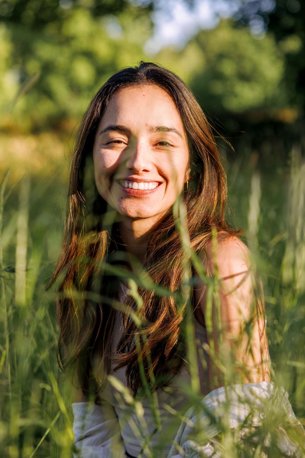 Joyful expressions in a sunny meadow with wildflowers and natural light.