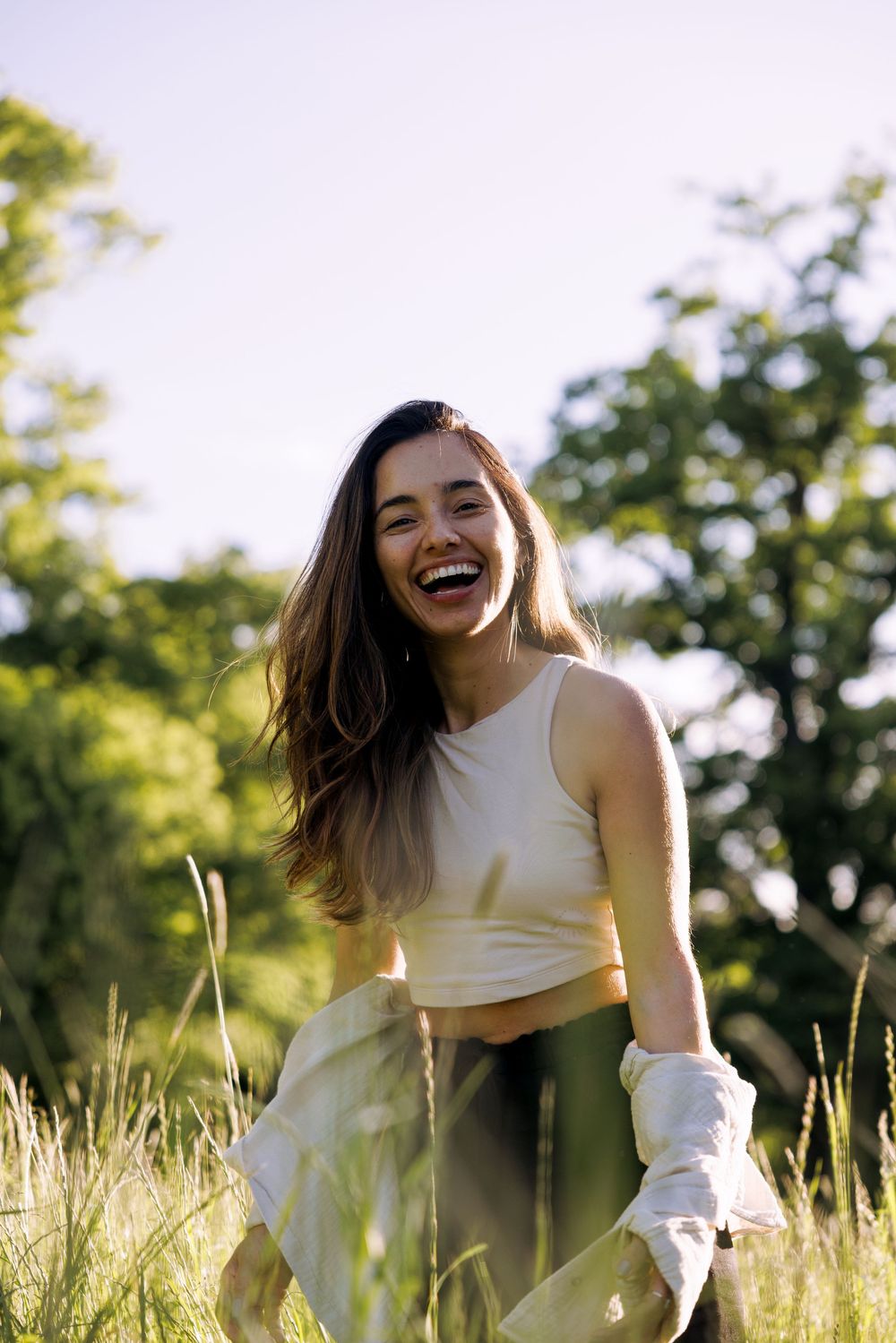 Carefree moments captured in tall grass with magical evening light.