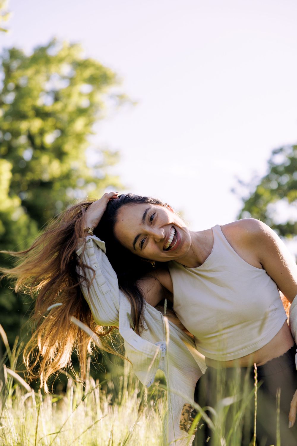 Dancing and twirling through a sun-drenched field of tall grass on a summer afternoon.