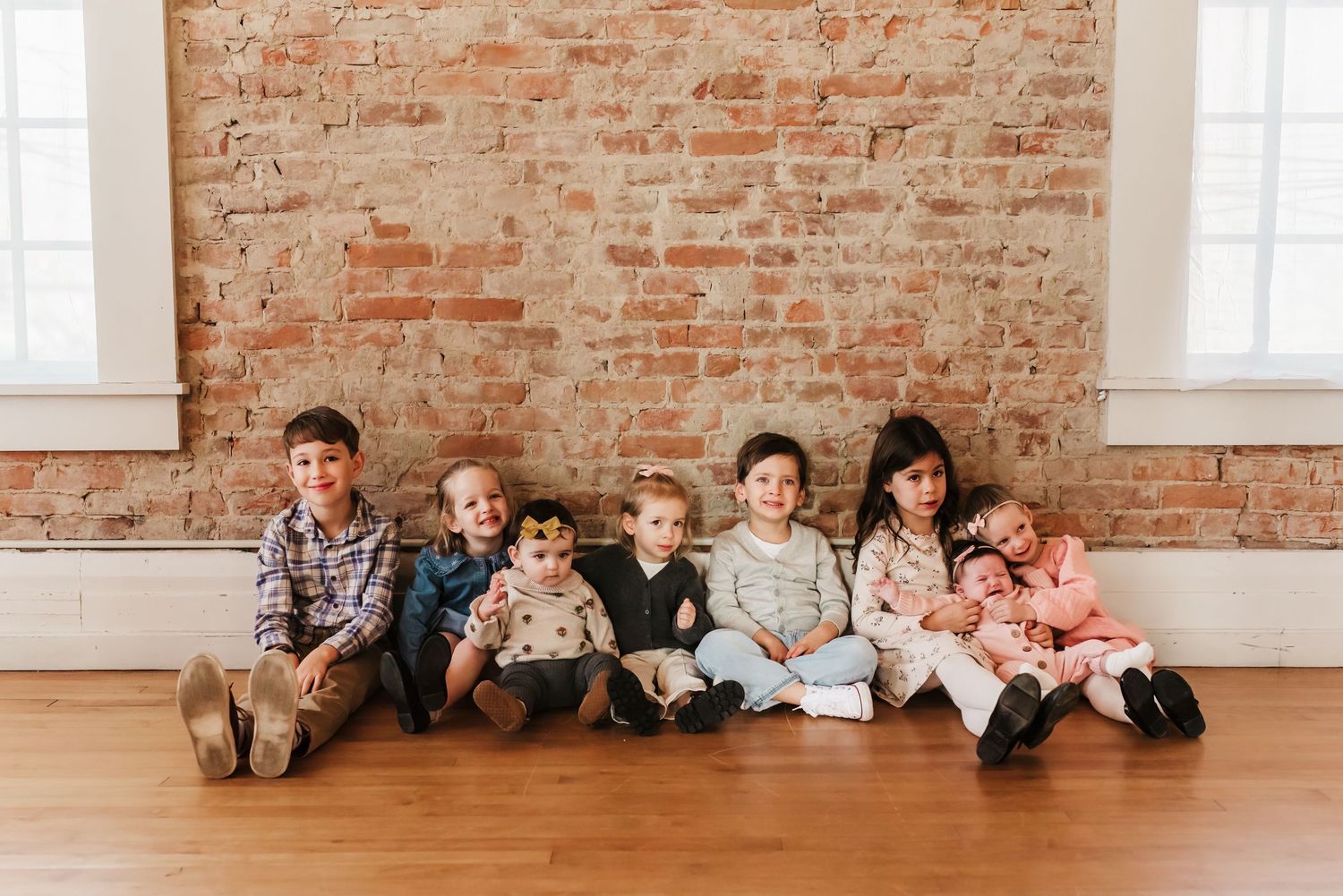 Cousins sit together and make silly faces during their extended family photo session in Cincinnati, Ohio
