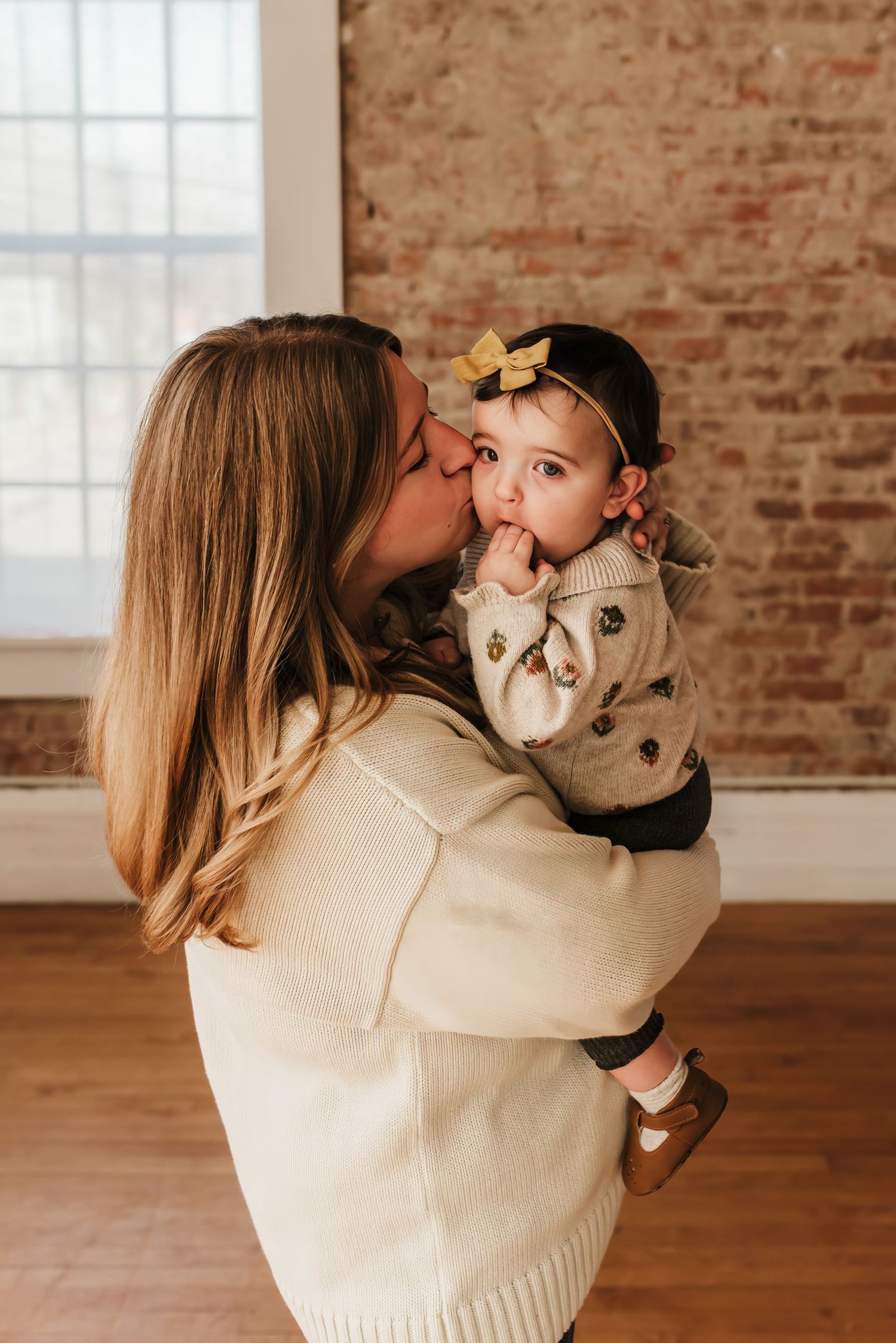 Mom kisses beautiful baby girl.