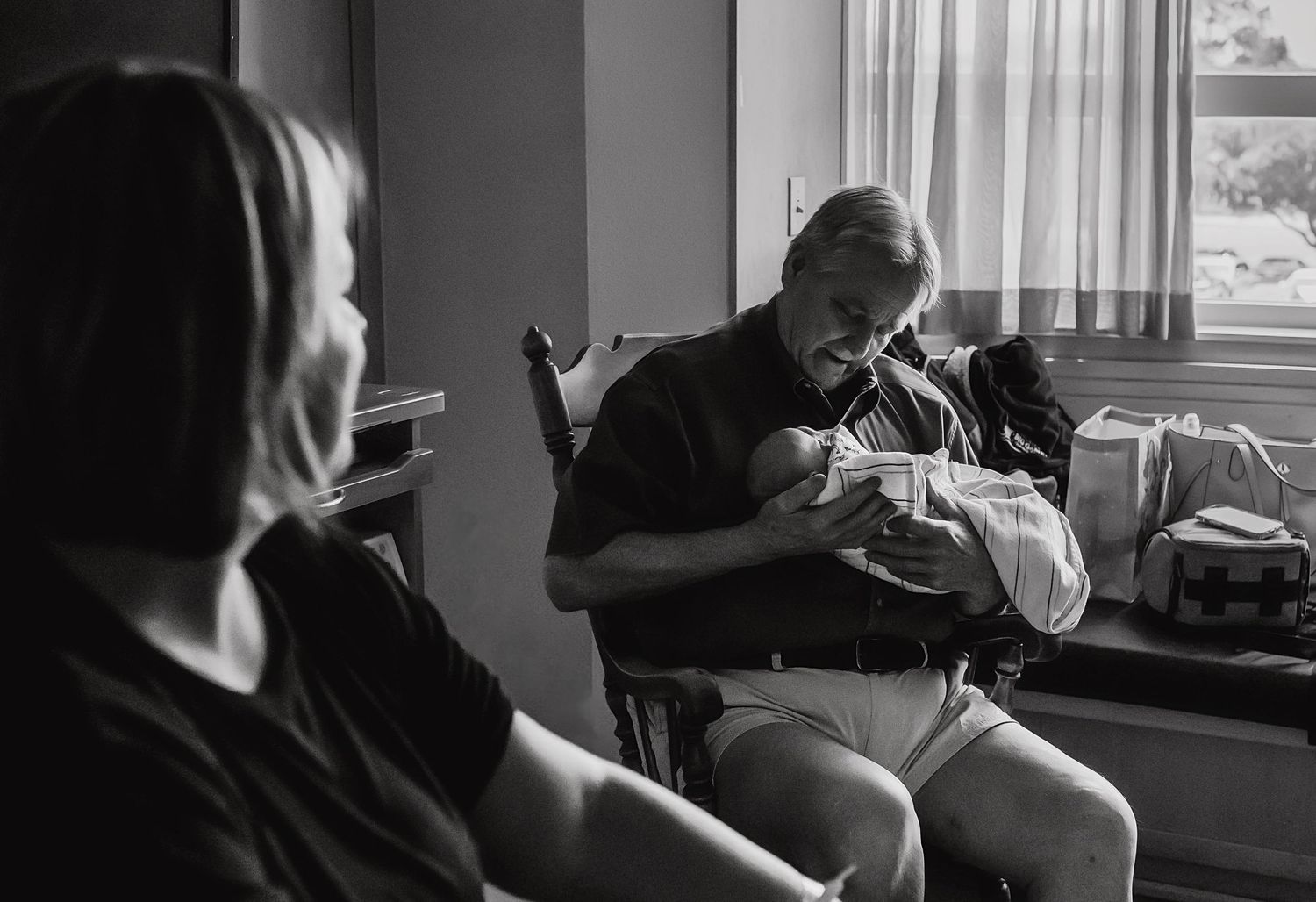 Three generations during fresh 48 session. Grandfather holds grandson for the first time while daughter looks on.