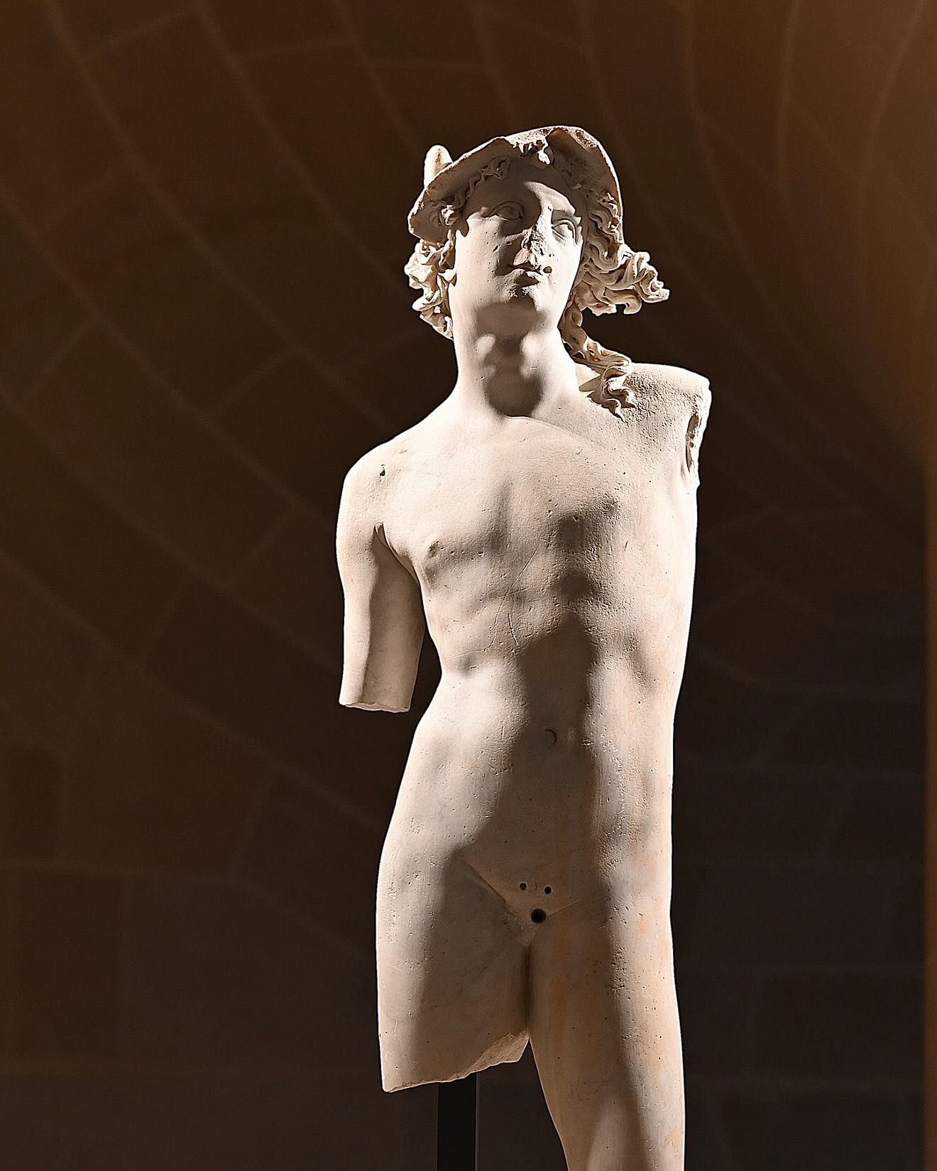 Artistic black and white photograph showing multiple angles of a classical nude torso sculpture against dark background.