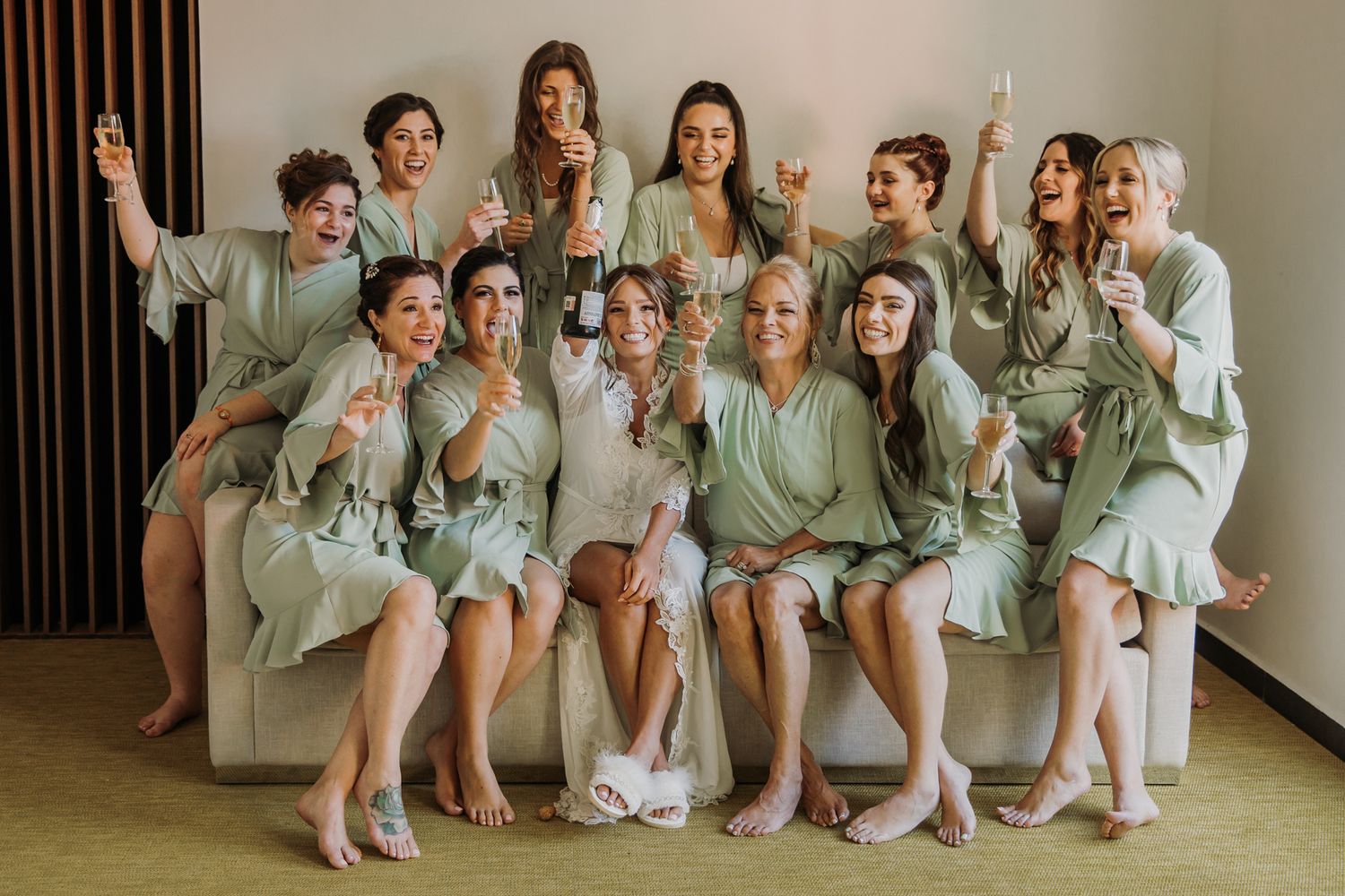 Bridesmaids wearing sage green dresses pose together in a series of candid group photos. El Dorado Royale Wedding Photographer