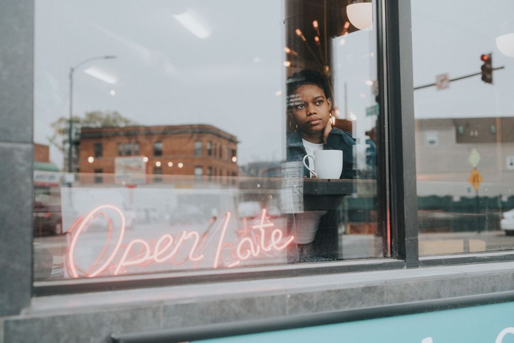 View through window of storefront with neon sign.