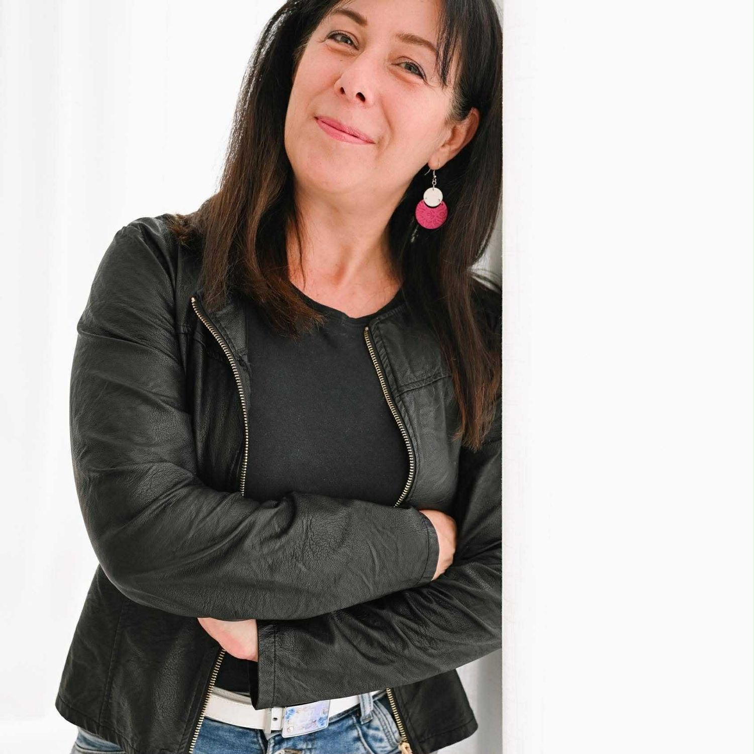 Person in black jacket posing casually against white background.