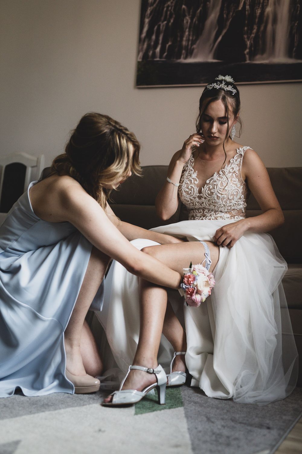 Wedding preparation scene showing details of bridal shoes and dress hem.