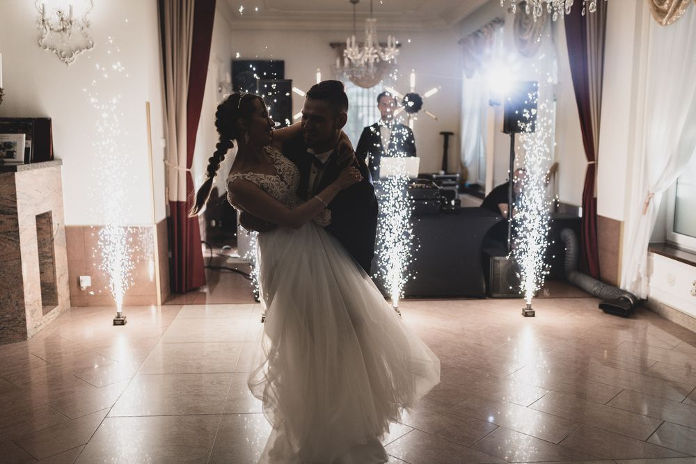 Wedding reception dance floor with sparkler effects and elegant lighting.