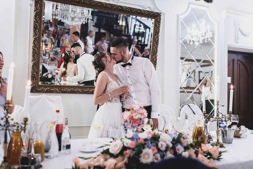 Wedding reception venue decorated with elegant chandeliers and white decor.