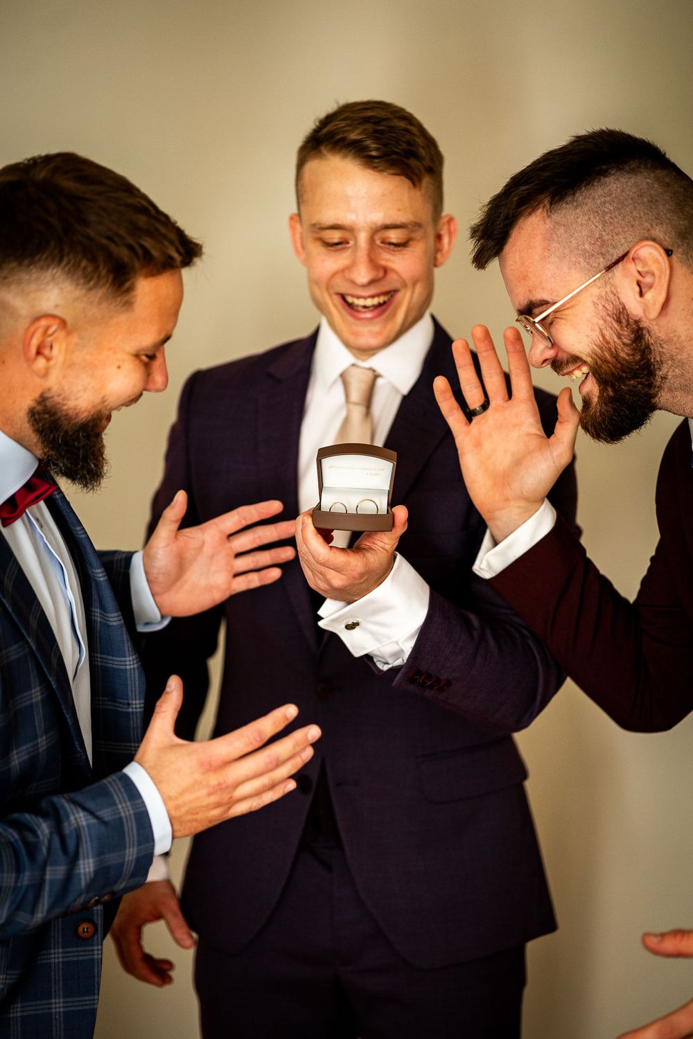 Three people sharing an excited moment while looking at a small box.