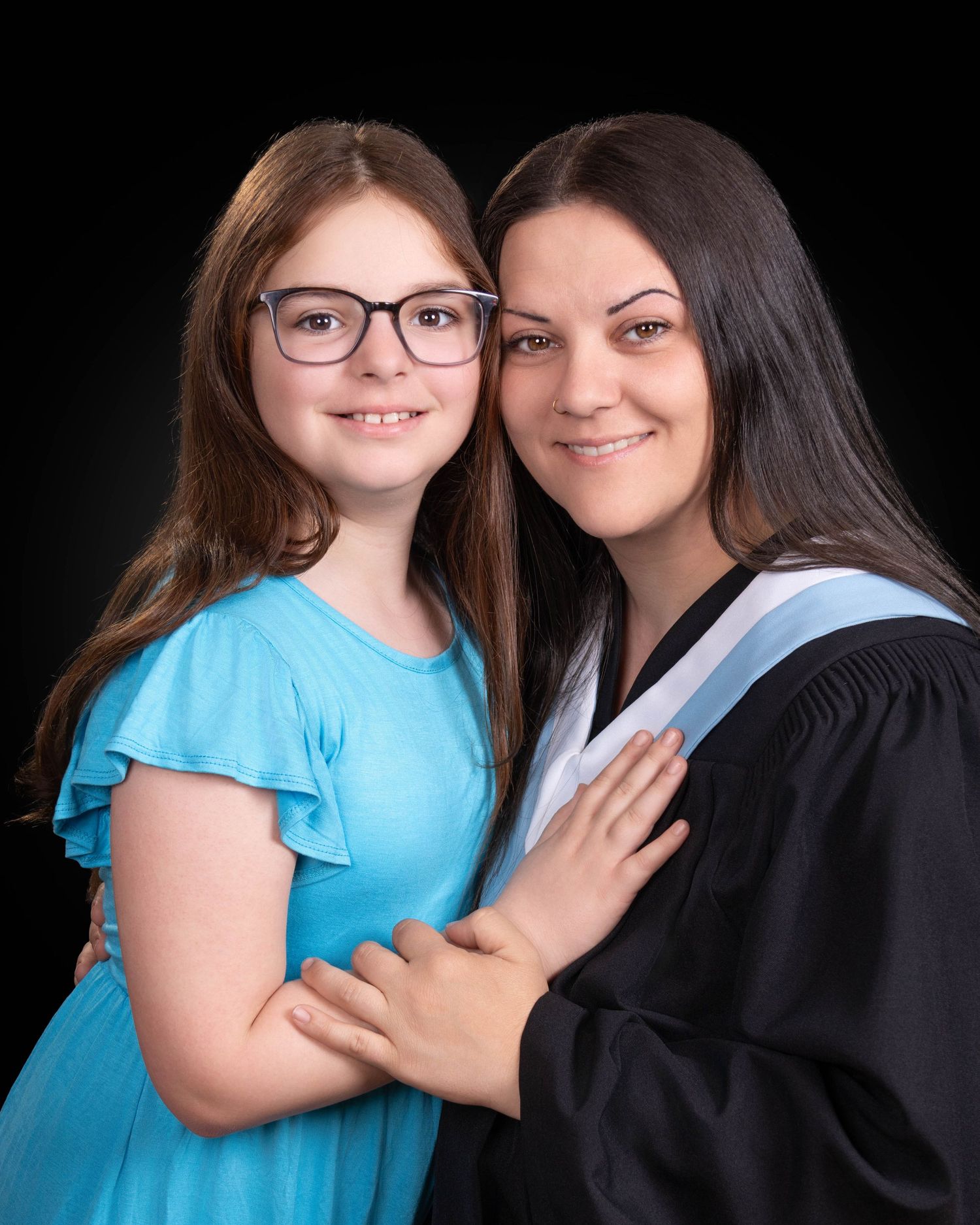Senior studio portrait with gown against gray/black background
