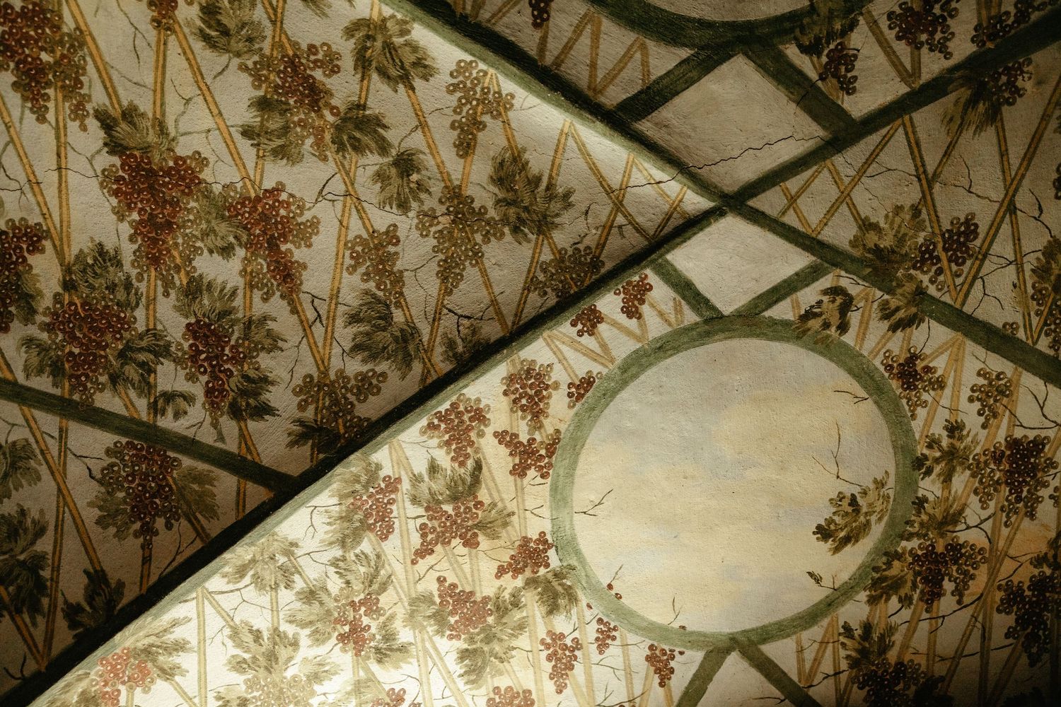 Ornate vintage floral wallpaper pattern with pink and brown flowers covers walls and ceiling in a room.