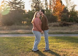 Couple walking together at sunset in autumn field with golden light.
