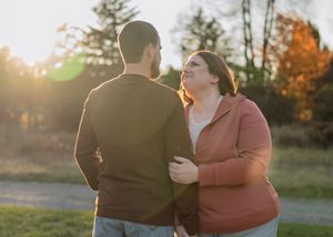 Intimate moment between couple during golden hour photoshoot in nature setting.