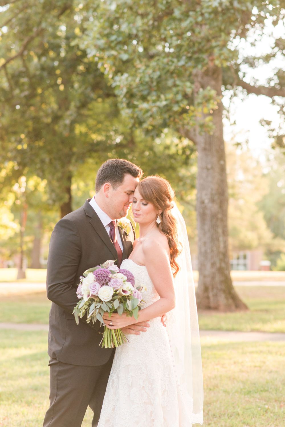 Romantic wedding portraits at sunset with golden light filtering through trees.