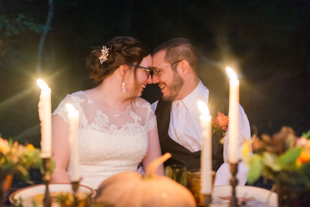 An intimate candlelit moment between newlyweds during their wedding reception.