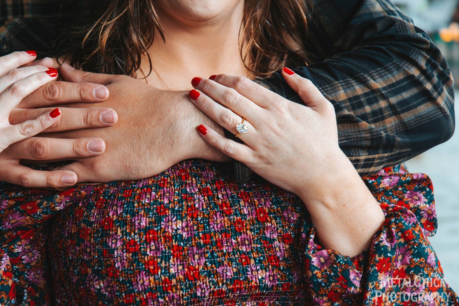 Engagement photo by Northern Exposure featuring a close-up of the engagement ring on the future brides hand with her fiances hand on her