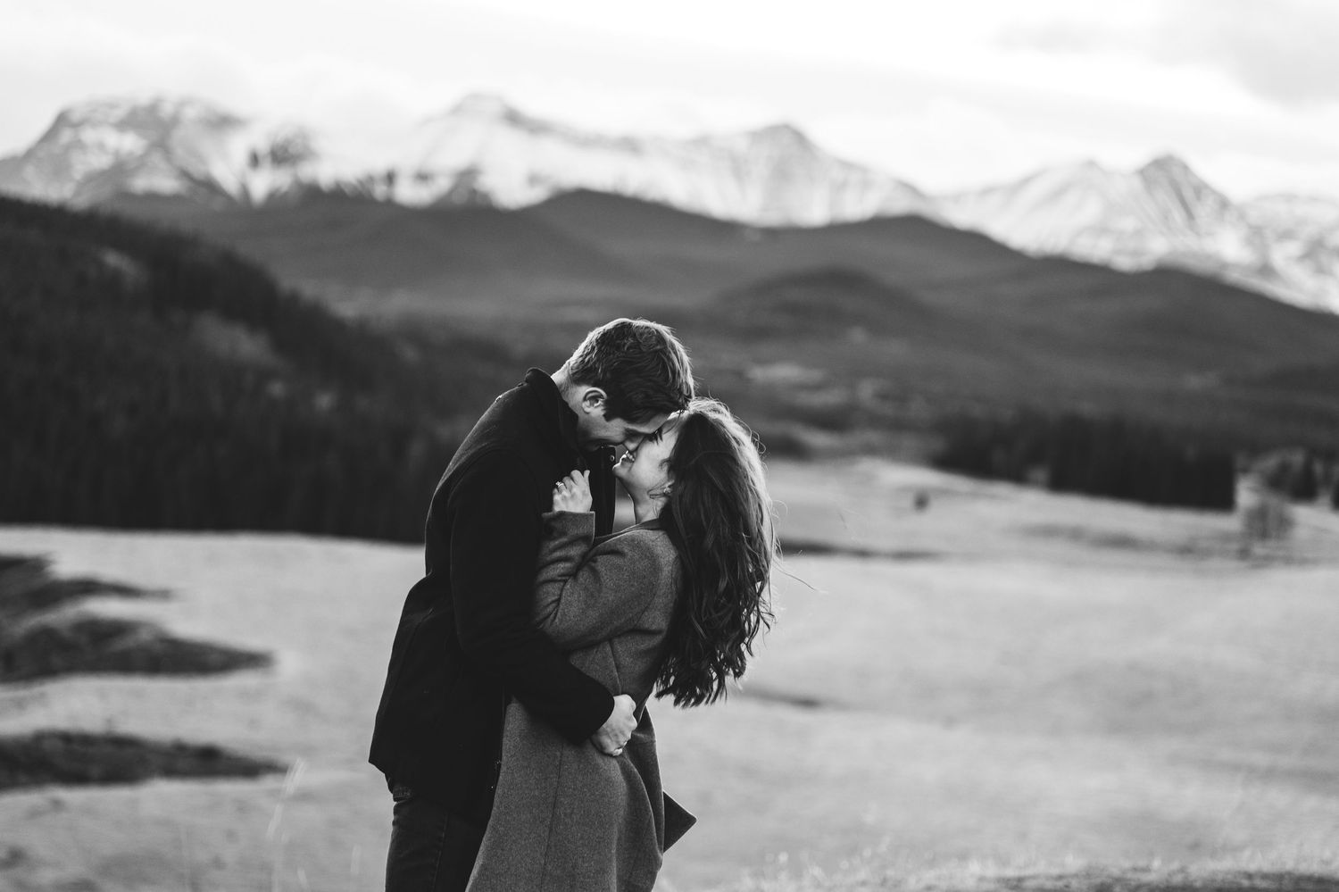 Dancing couple silhouetted against dramatic mountain landscape.