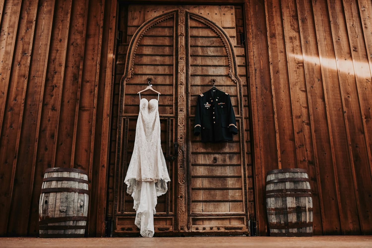 Editorial bridal gown hanging on rustic Lucky Spur Ranch doors with soft natural light.