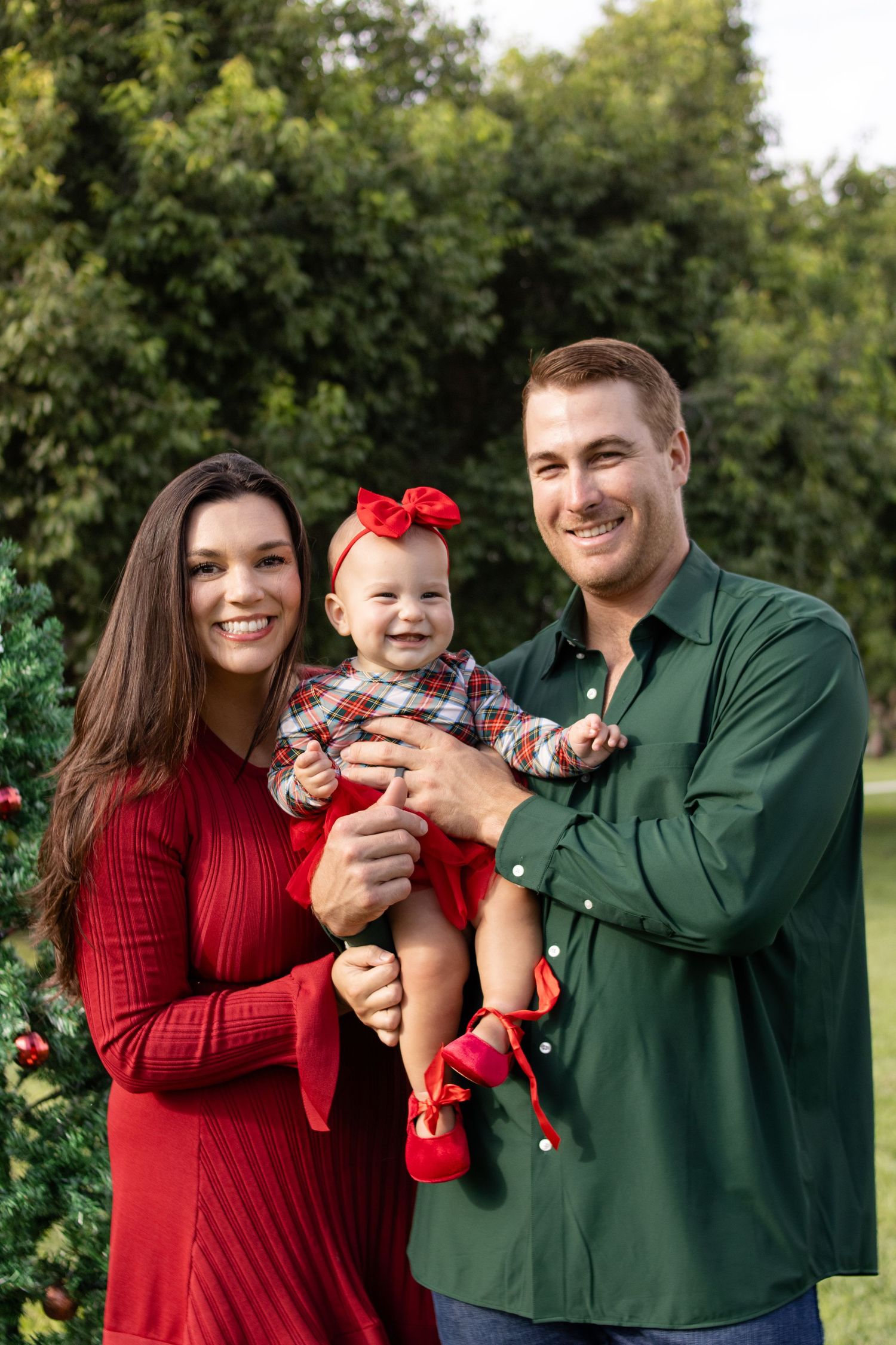 family of 3 smiling christmas photo