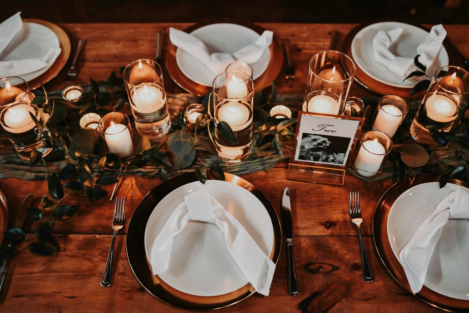 twinkling lit flames inside glass votives line the sweetheart table at lucky spur ranch