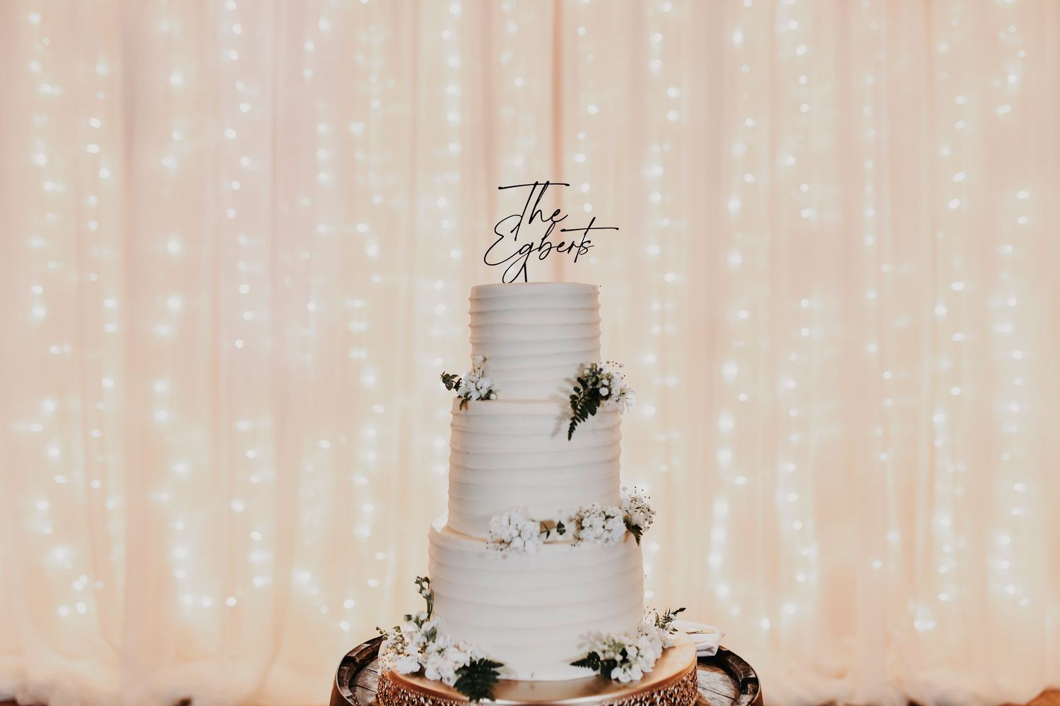 Editorial wedding cake with soft olive and sage accents displayed at Lucky Spur Ranch reception.