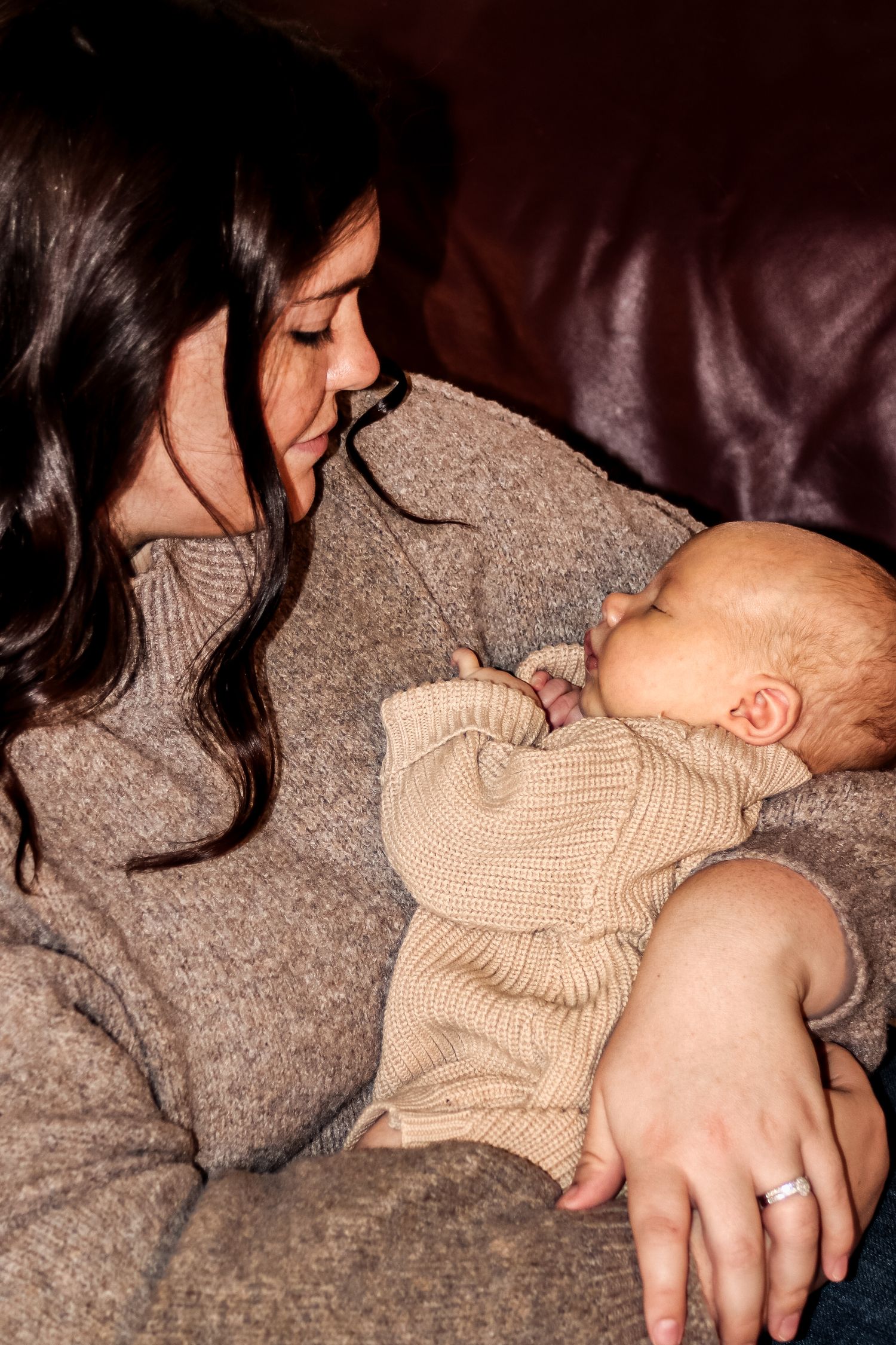 Intimate in home lifestyle, newborn photo of a parent, holding their baby and soft natural light in Michigan