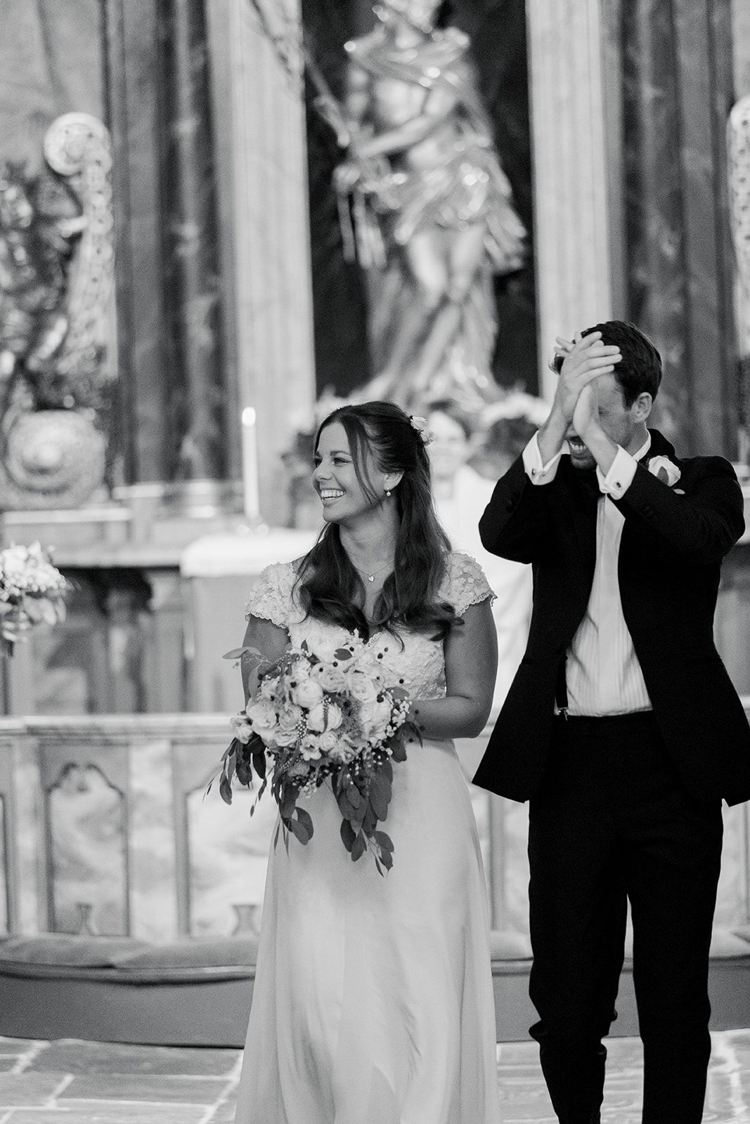 Black and white wedding photos showing romantic moments between couple in formal attire at elegant venue with statues.