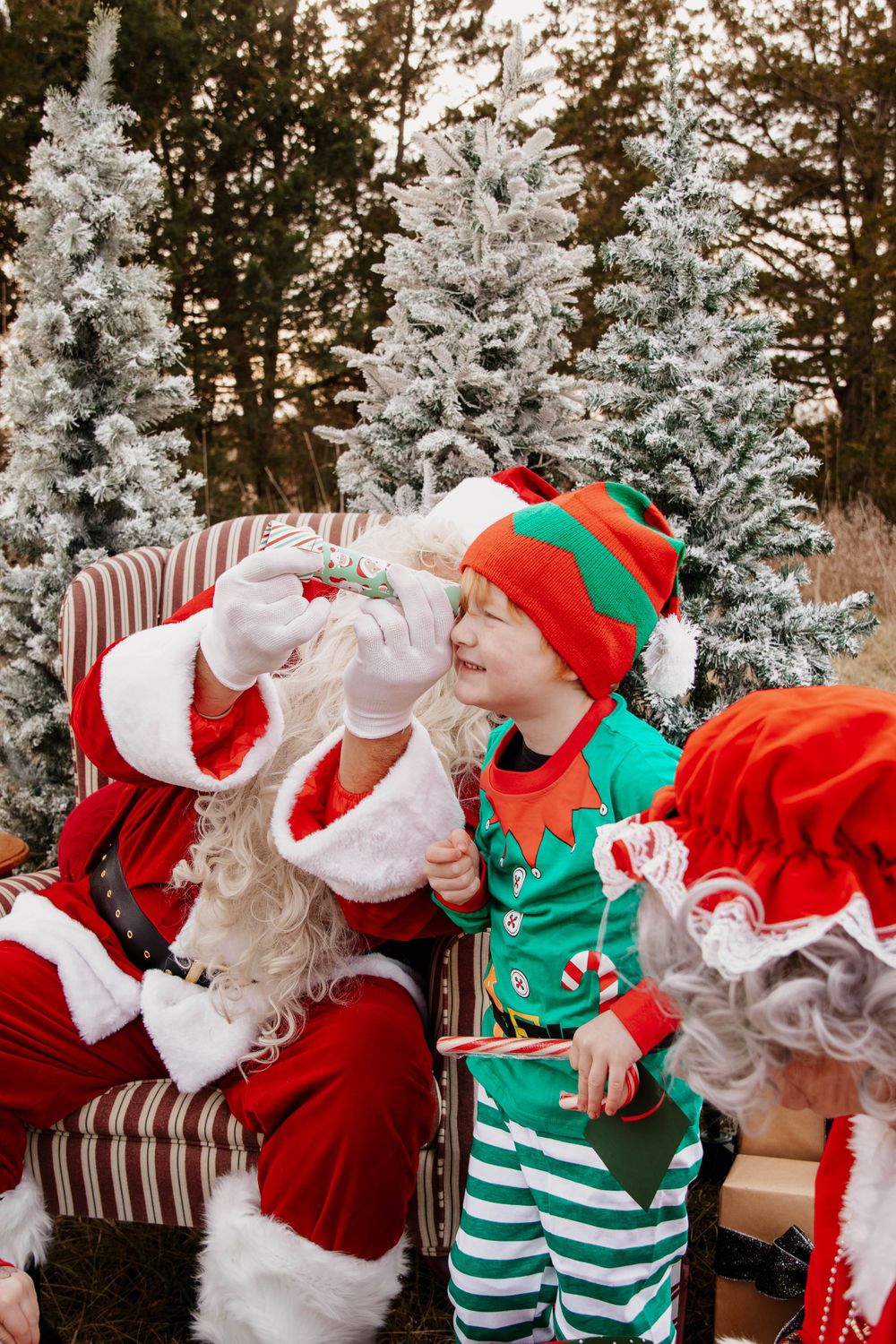 A festive Christmas scene with striped flocked trees and traditional holiday costumes against an autumn backdrop.