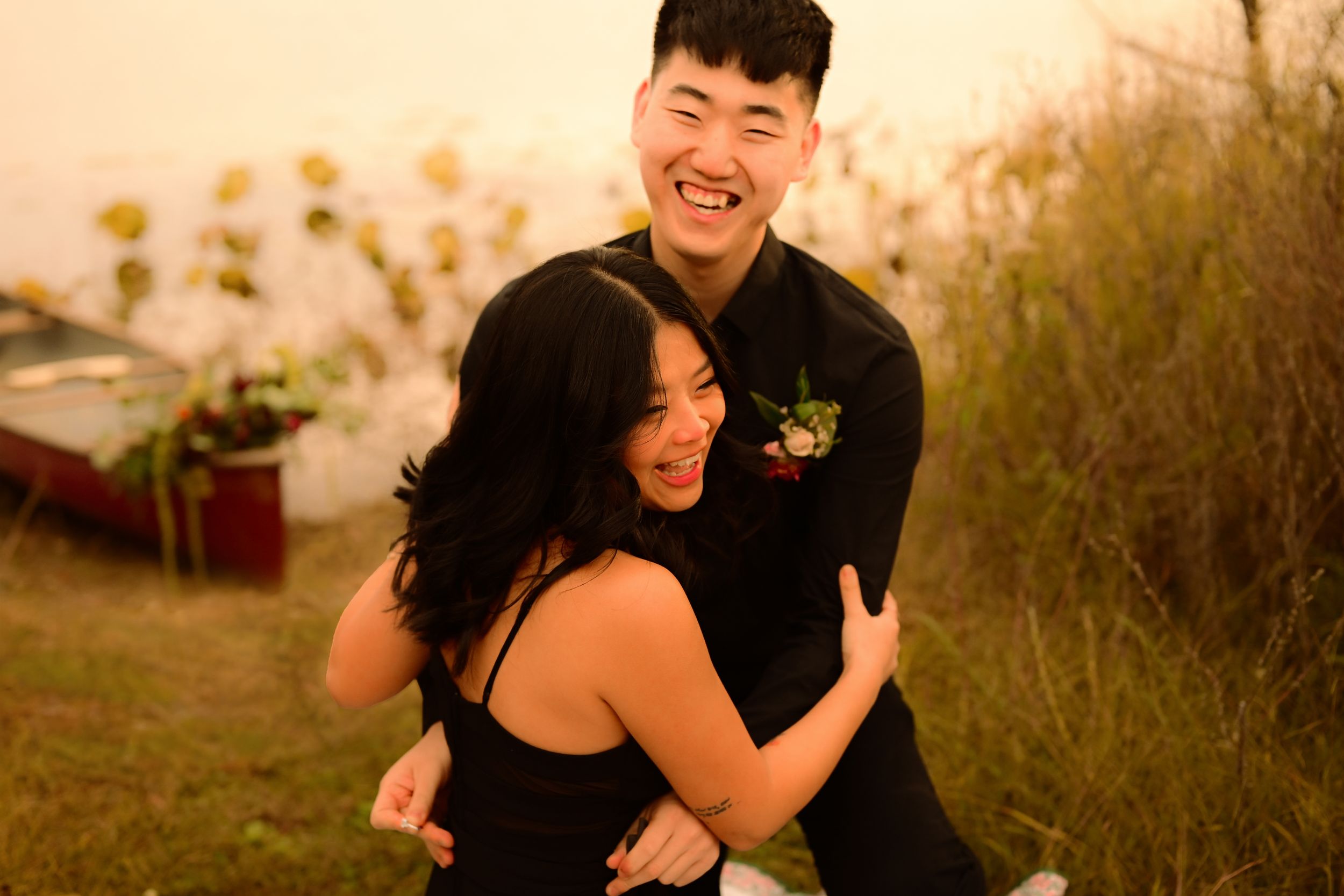 A couple shares a romantic moment during sunset in a natural outdoor setting.