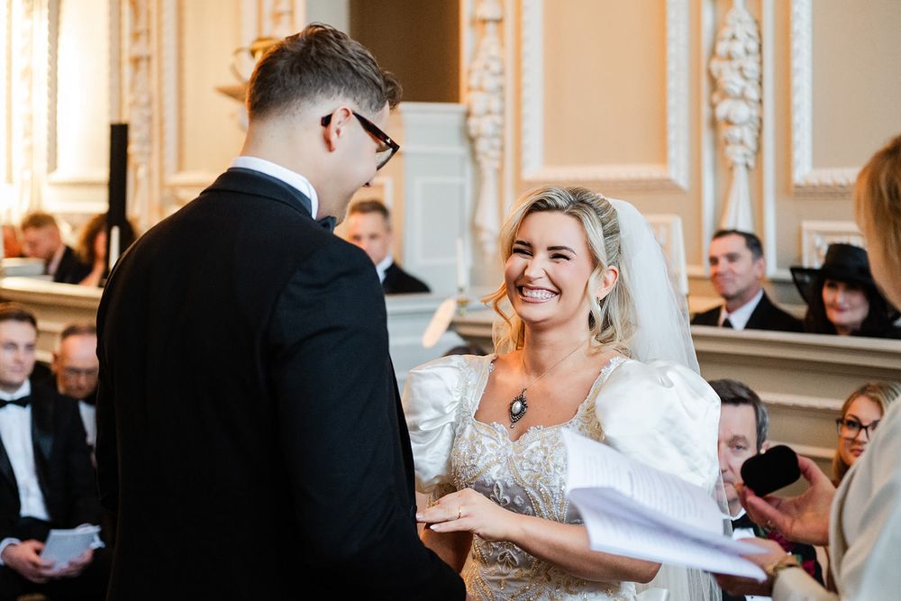A bride and groom share a joyful moment during their first dance at an elegant wedding reception.