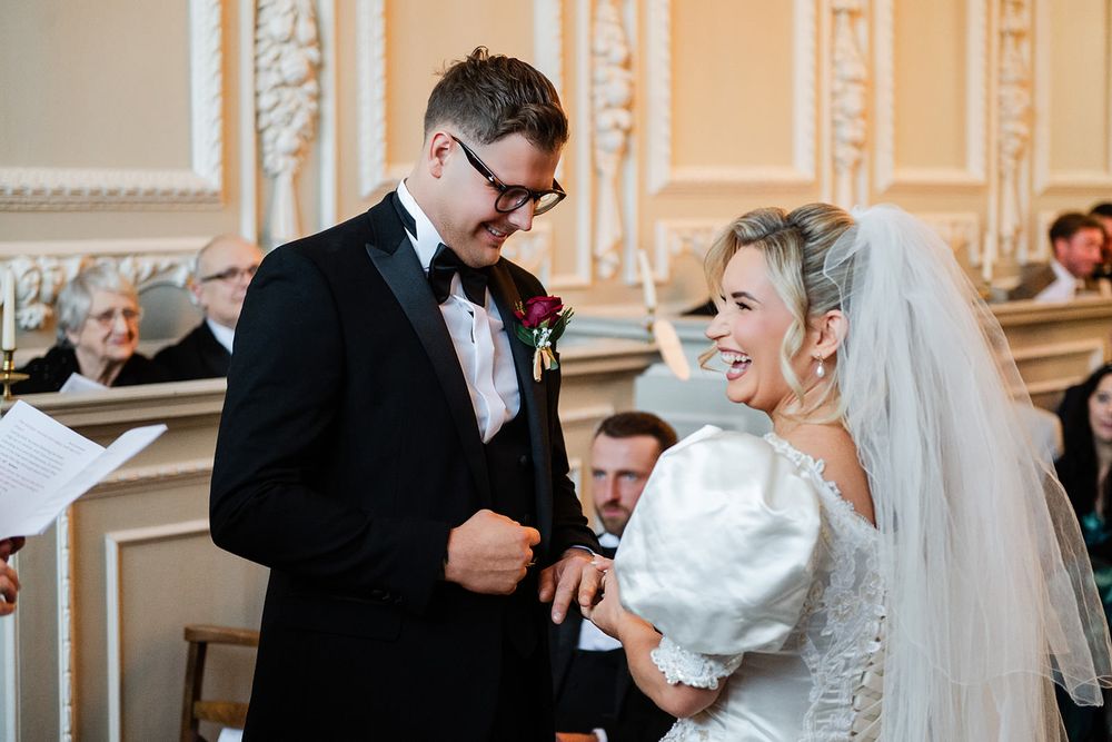 Wedding couple shares a joyful moment during their first dance at an elegant ballroom reception.