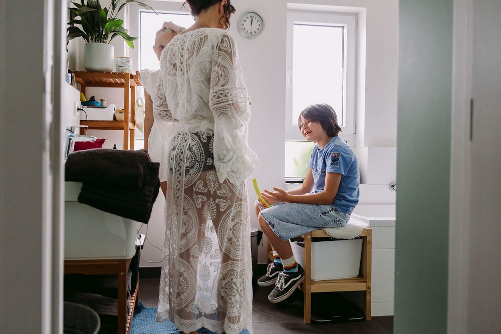 Medical professional in protective gear consulting with patient in bright examination room.