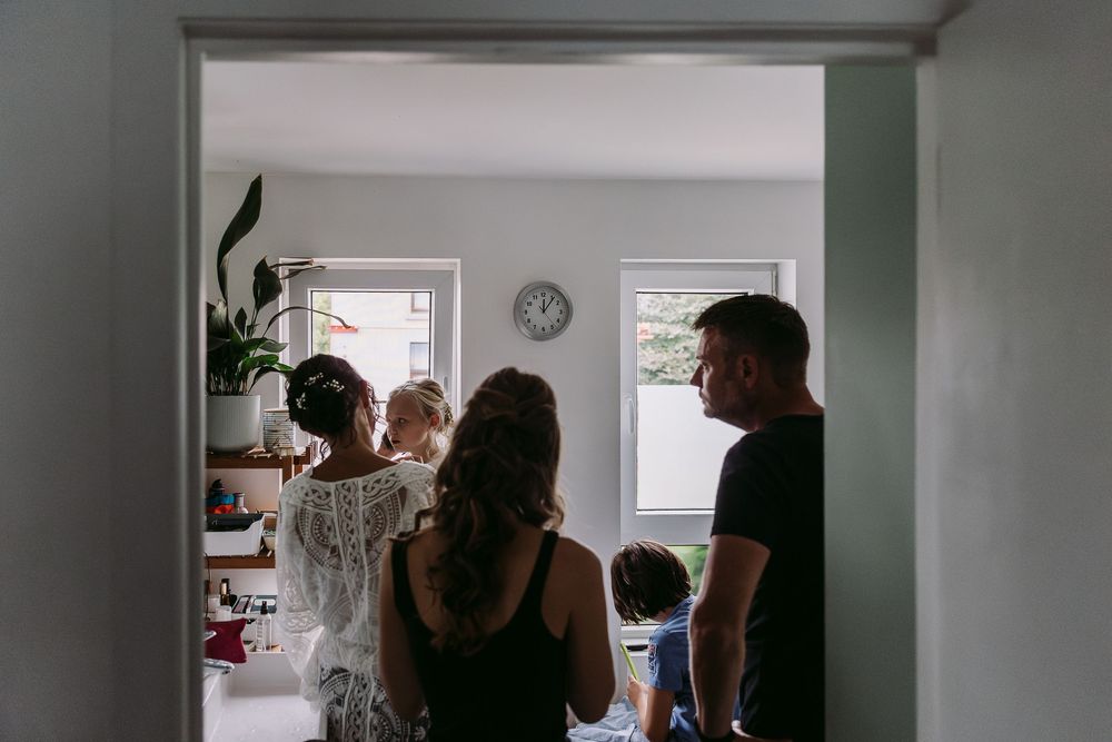 People gathered in a modern interior space with mint green walls and natural lighting.