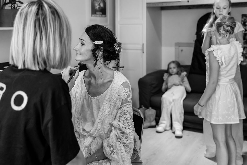 Black and white photo of a joyful wedding celebration with guests dancing and socializing indoors.