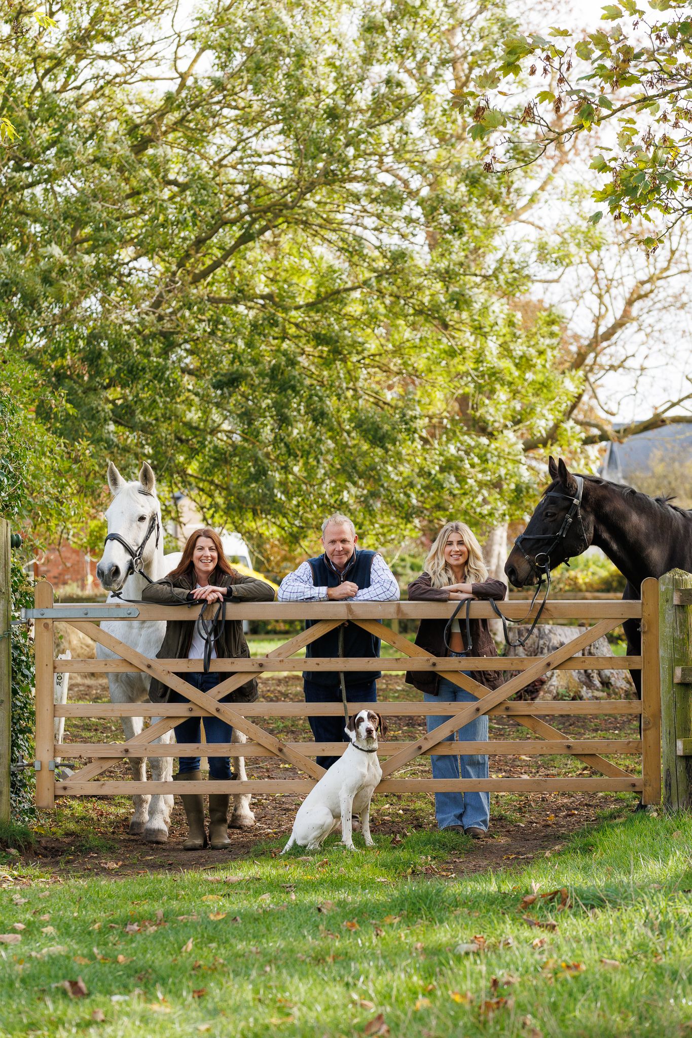 A horse and its rider enjoy an outdoor photoshoot session near rustic wooden fencing on a sunny day.