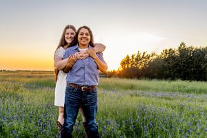 Couple sharing a joyful moment in a field of bluebonnets during sunset.
