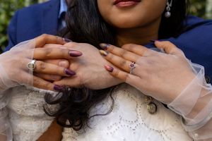 A close-up view of hands with engagement rings showing wedding day details.