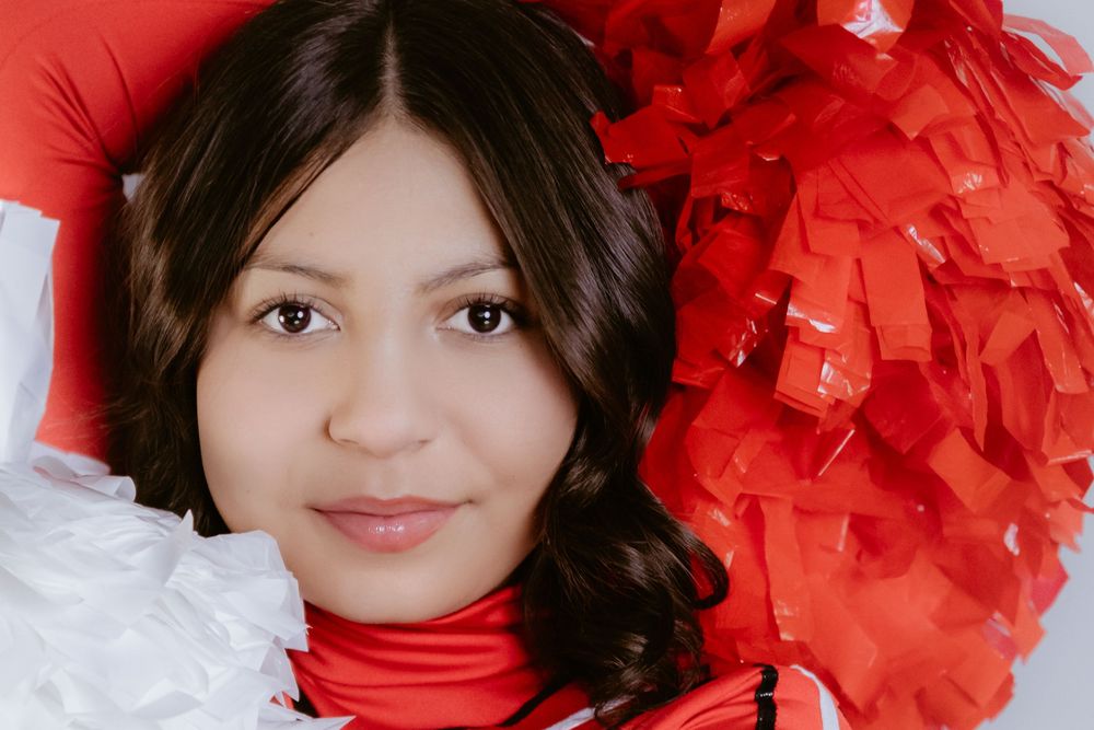 Portrait against red and white background with festive tissue paper decorations.