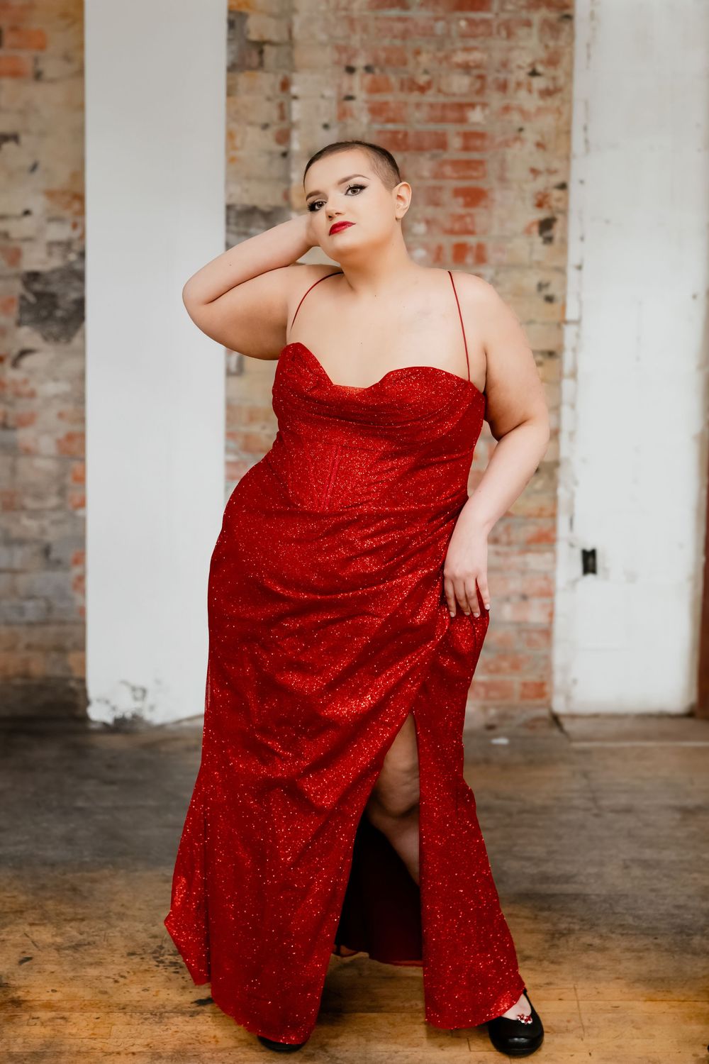 Red sequin dress photoshoot in industrial space with brick walls.