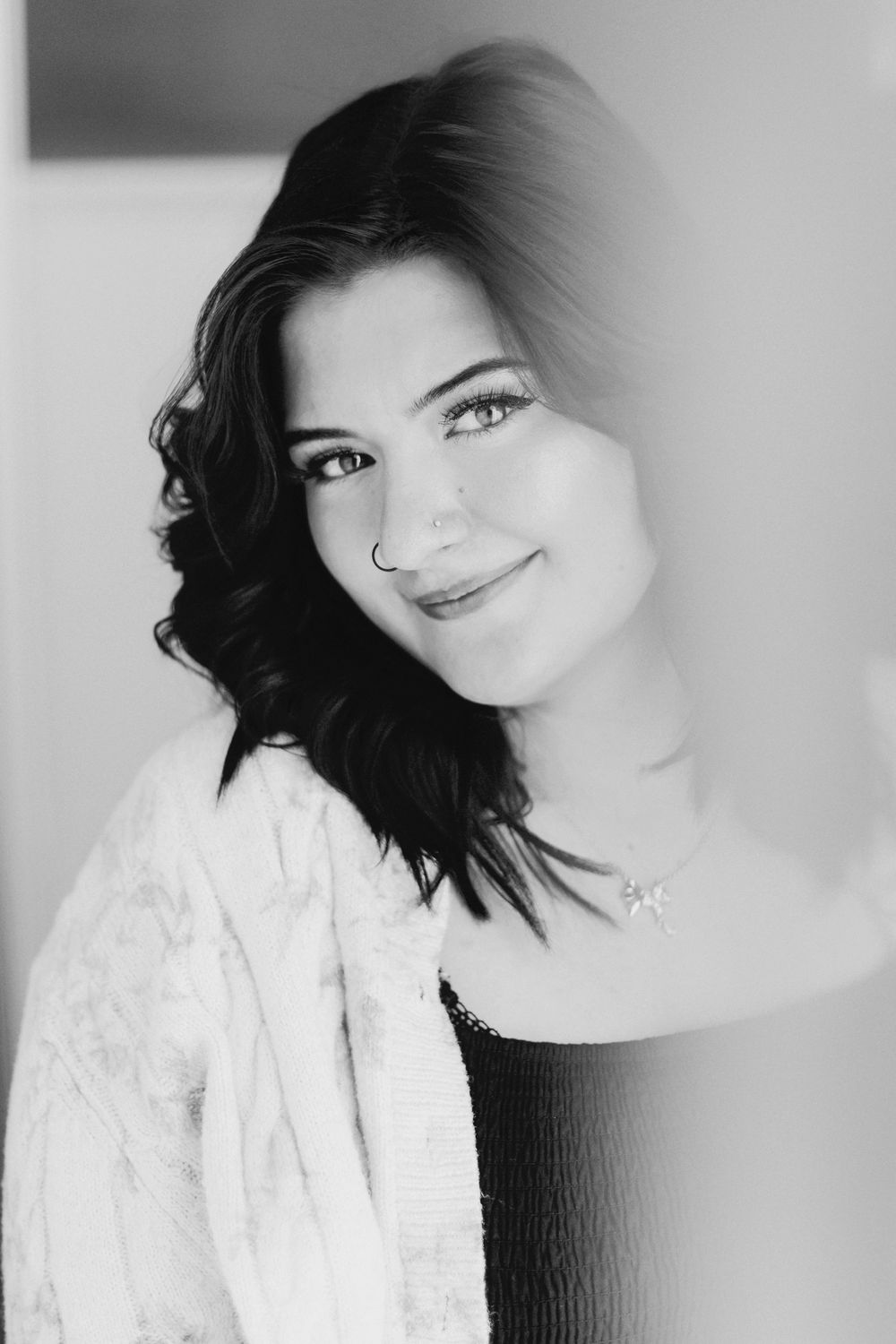Black and white studio portrait with soft lighting and lace details.