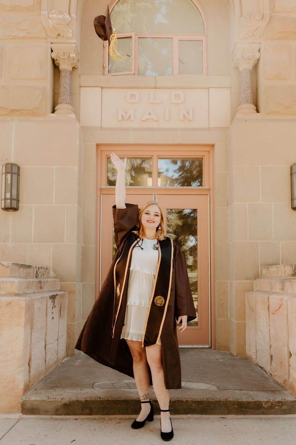 Graduation photos taken at historic university building entrance.