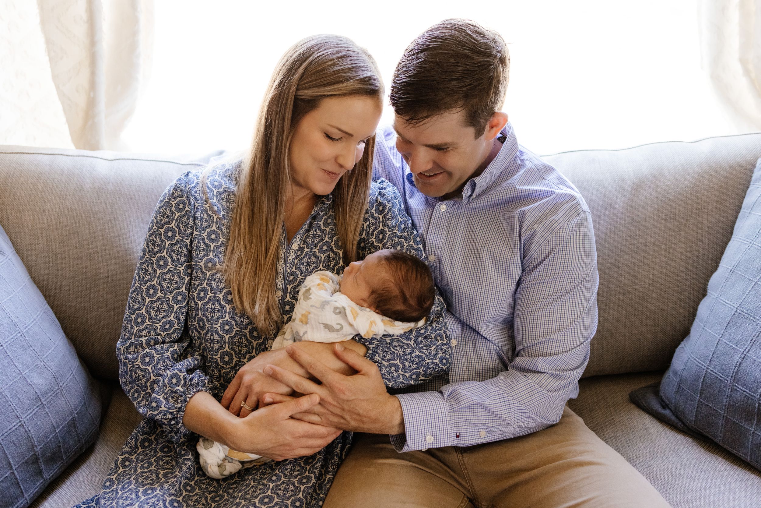 Dad and mom cuddle their new baby