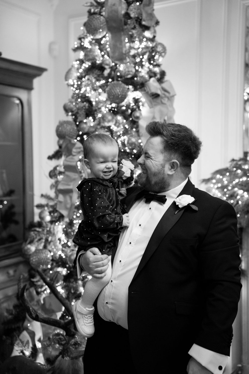 Festive holiday wedding celebration with decorated Christmas trees in the background.
