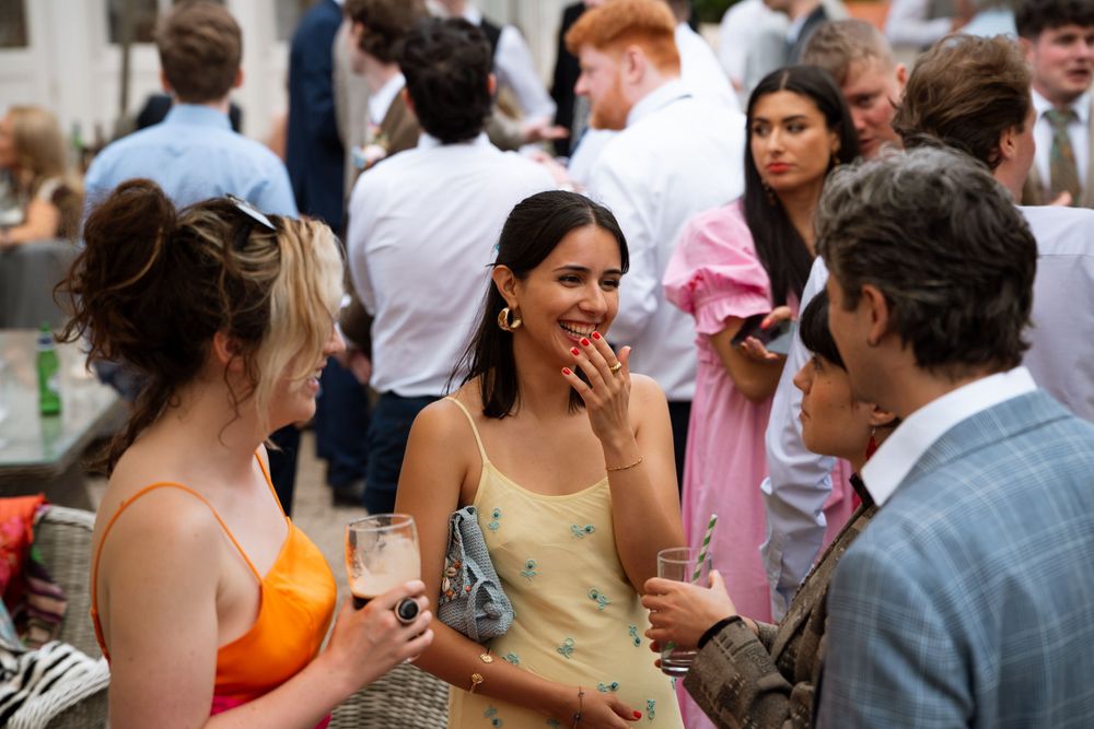 Wedding guests laughing and enjoying themselves during an outdoor reception celebration.