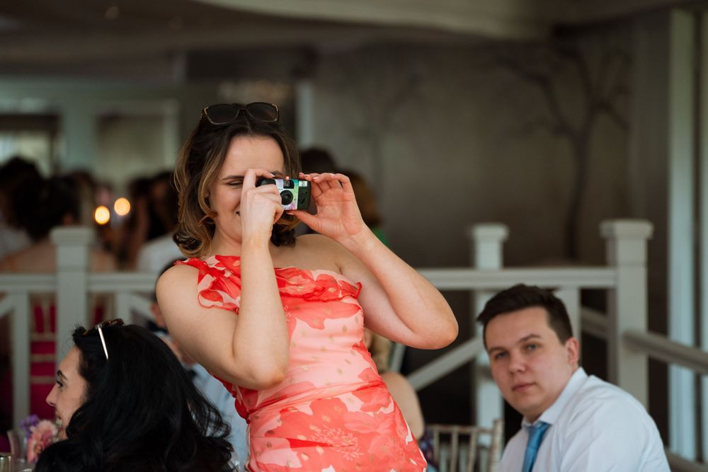 Wedding celebration with guests dancing and mingling at an indoor venue.